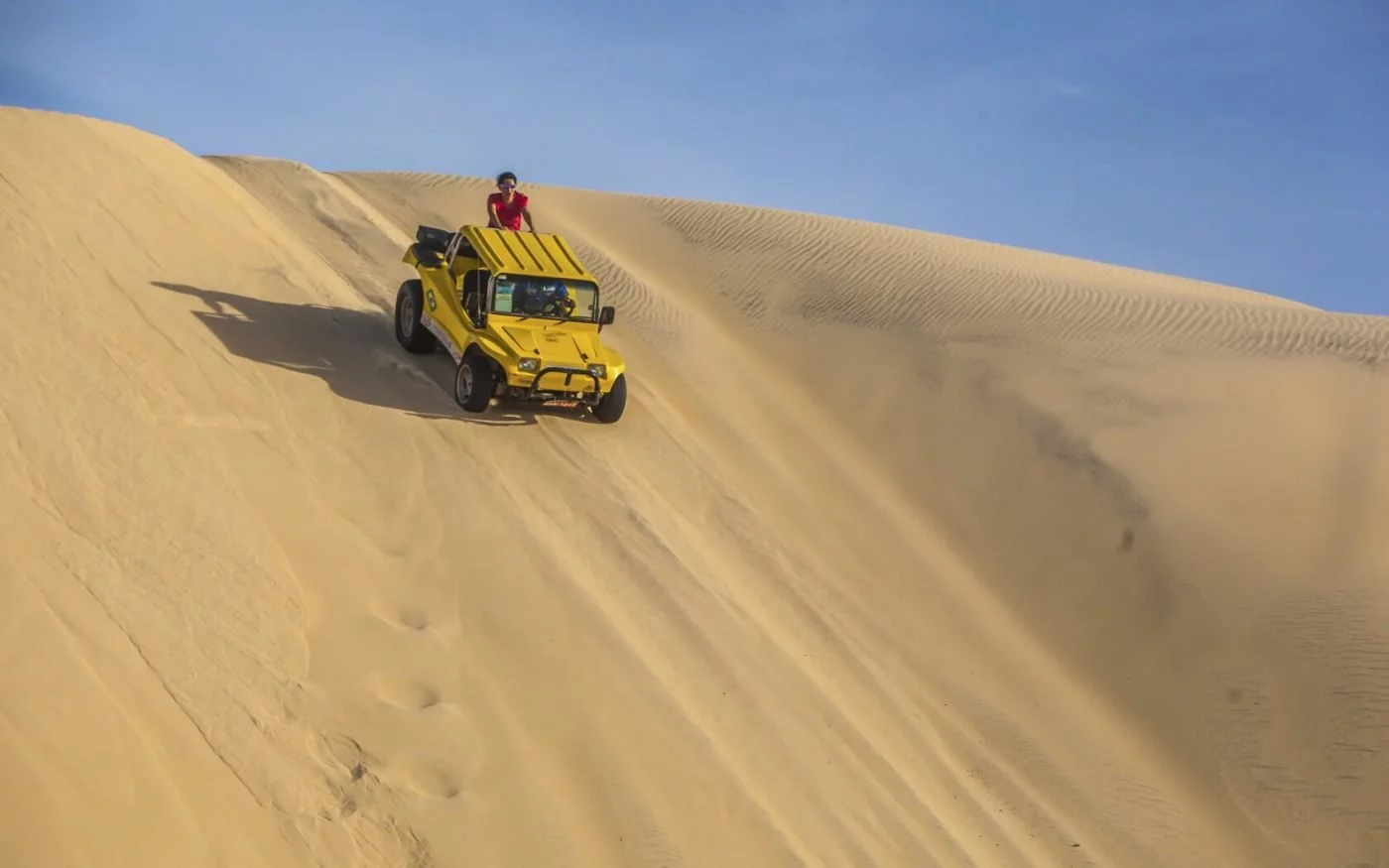 buggy amarelo descendo nas dunas de Fortaleza