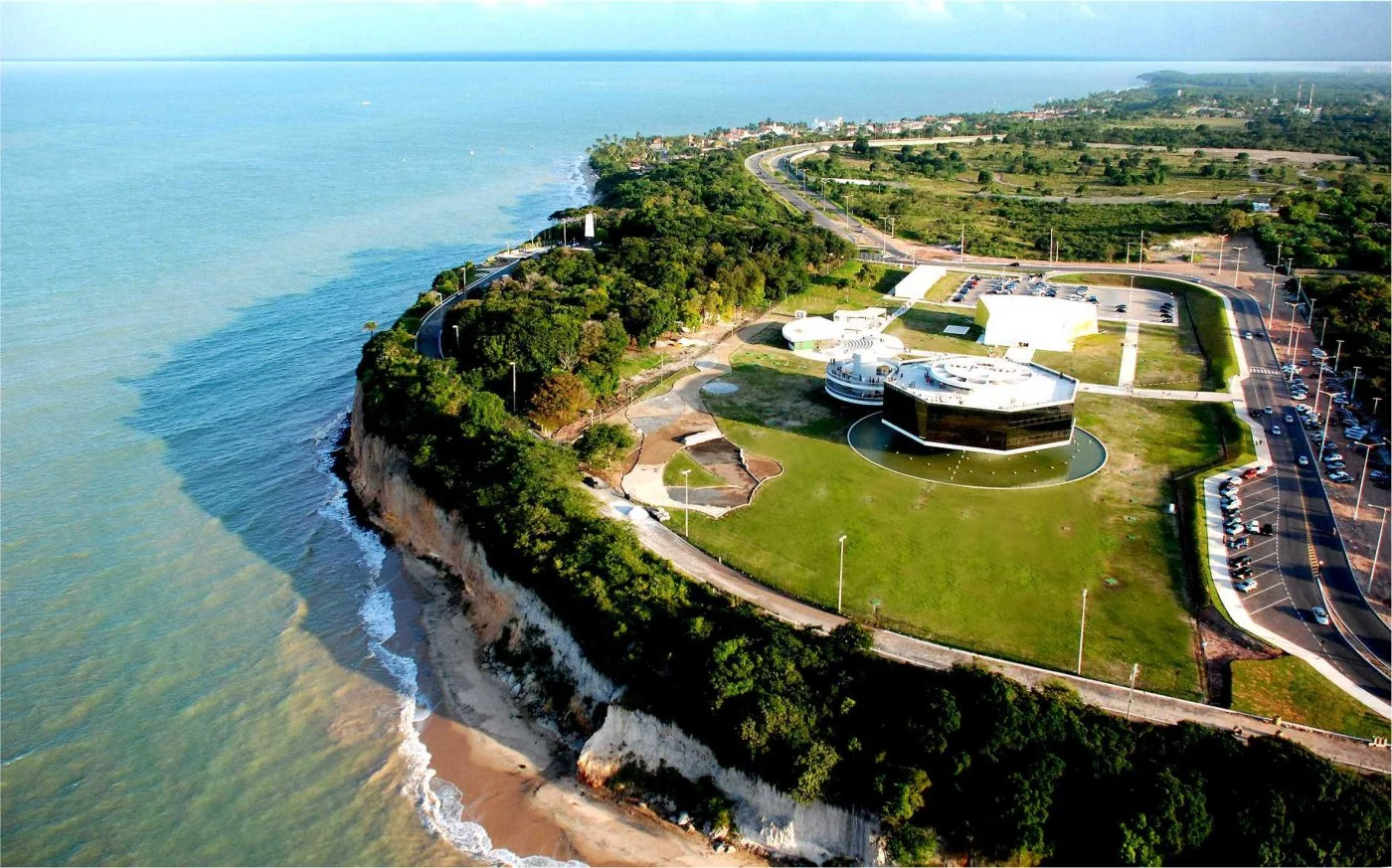 construção em meio a um pátio de grama com vegetação com vista para o mar em João Pessoa