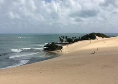 praia com dunas e vegetação ao fundo em Natal
