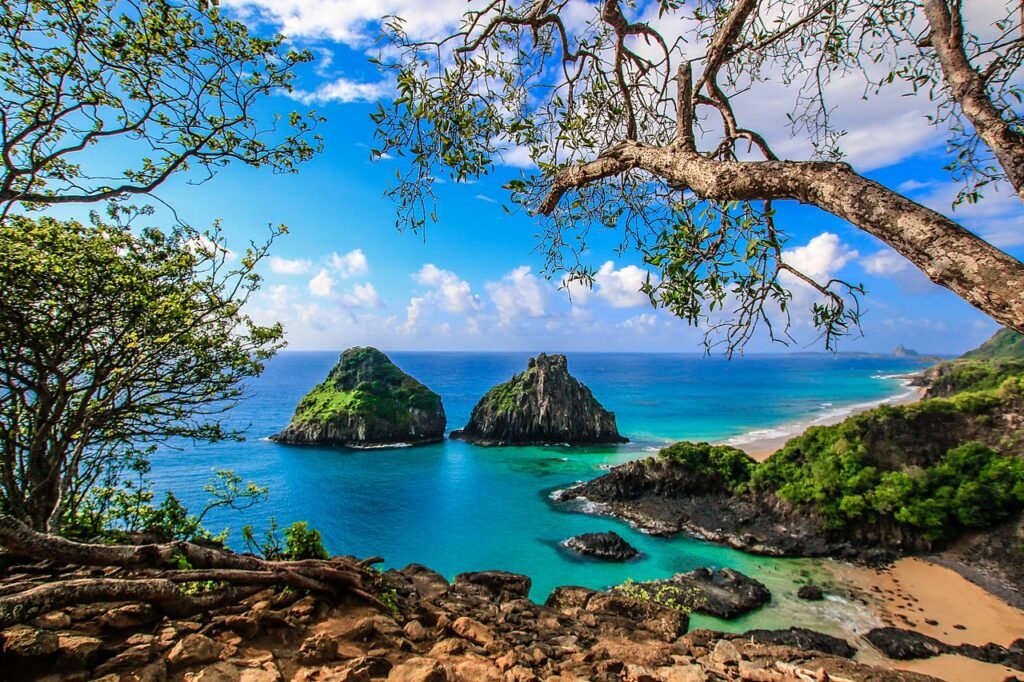 morro com vegetação e dois morros no mar em Fernando de Noronha