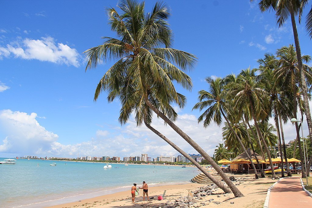 coqueiros e banhistas na areia da Praia de Pajuçara em Maceió