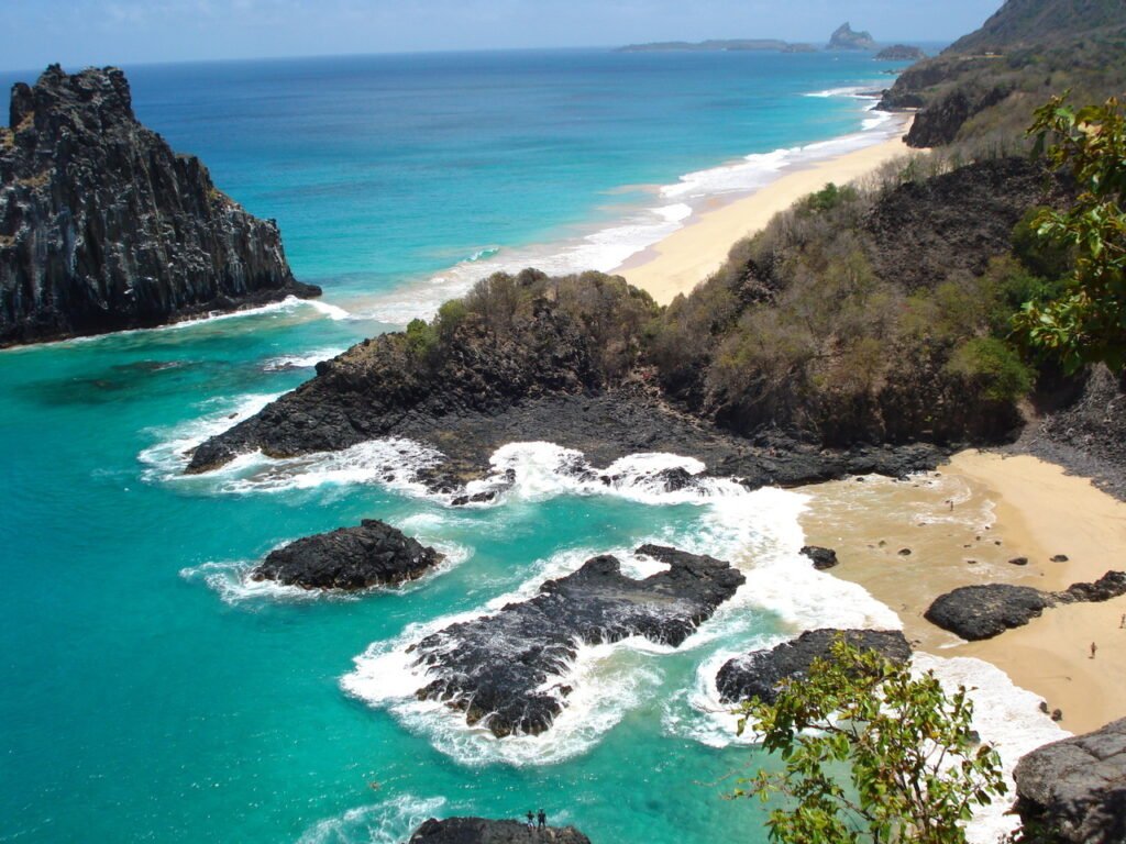 Rochas nas águas da Baia dos Porcos e mar com pequenas ondas em Fernando de Noronha