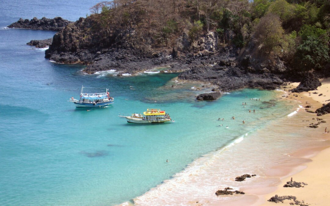 dois barcos e turistas nadando na baira da Praia do Sancho em Fernando de Noronha